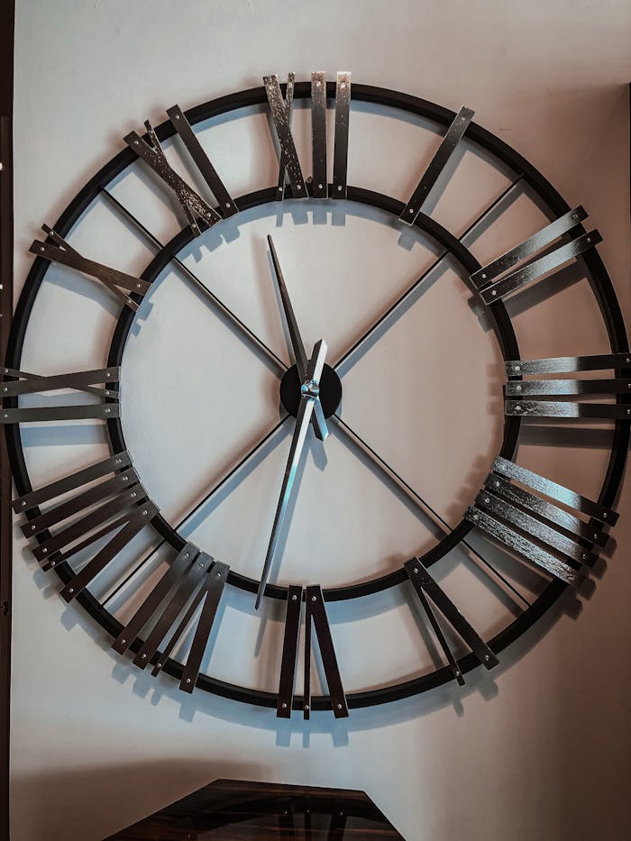 Close-up of a stylish Roman numeral clock on a wall, perfect for modern interior design.